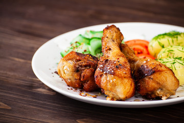 Grilled chicken drumsticks with boiled potatoes and vegetables