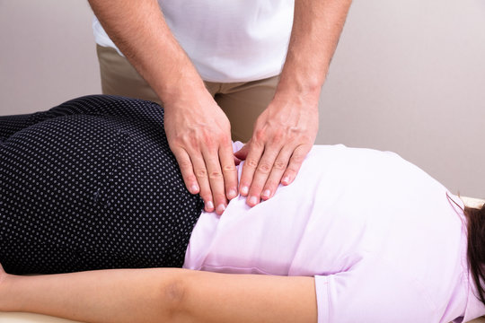 Physiotherapist Doing Female's Back Massage In Clinic