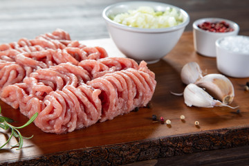 Raw minced pork on cutting board and vegetables