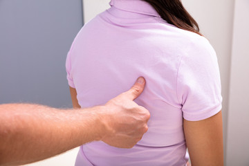 Physical Therapist Helping Female Patient With Back Pain