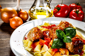 Pasta with meatballs on wooden background