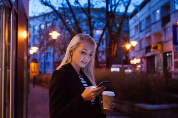 Young woman using smart phone outdoor in the evening