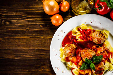 Pasta with meatballs on wooden background