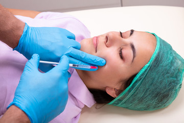 Doctor Giving Facial Skin Lifting Injection On Woman's Face