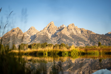 Rocky peaks of the Grand Tetons reflected in the river