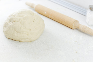 Flour on the table. Pizza dough. Rolling pin for the test. Dough with rolling pin.