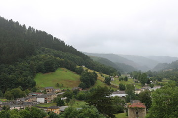 Village and mountains with gray sky, fog and rain