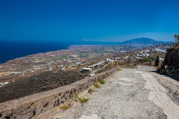 Couple of tourists at the walking trail number 9 between the cities of Fira and Oia in the Santorini Island