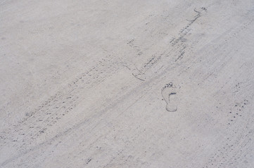Road tire and human footprint on the road. Background texture, pattern. The texture of the tire and foot design. A footprint of a man's and machine's feet.