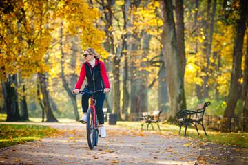 Urban biking - woman riding bike in city park