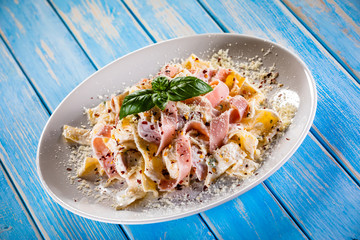 Pasta carbonara on white plate on wooden table