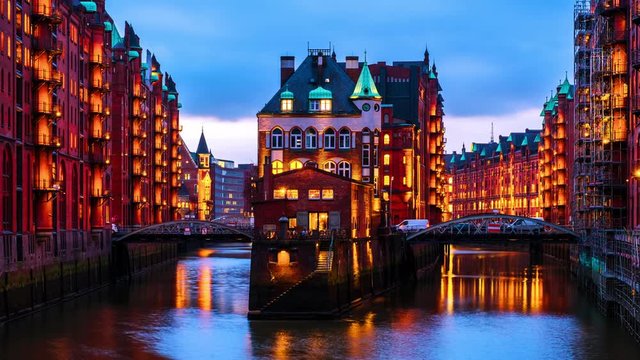 Hamburg, Germany. Night view of Speicherstadt in Hamburg, Germany. Time-lapse with illuminated historical buildings at sunset with reflection in the water, zoom in