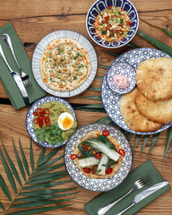 A variety of dishes on a wooden table. Restaurant serving. Top view.