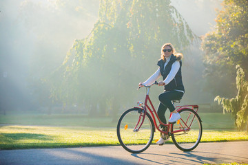 Urban biking - woman riding bike in city park