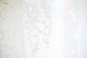 Delicate, soft Christmas background with blurry bright bokeh. New Year greeting card with white hydrangeas. Uniform texture for wedding invitations. Copy space. Substrate for printing products. Tender