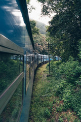 Blue train crossing a tea plantation in Sri Lanka