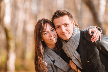 Happy family walking in autumn park on sunny fall day