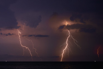 Naklejka na ściany i meble Lightning in a storm over the sea