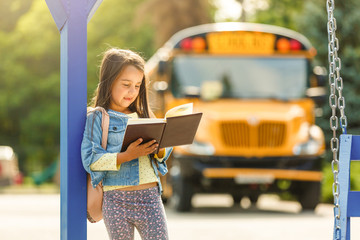 schoolgirl is waiting for a school bus