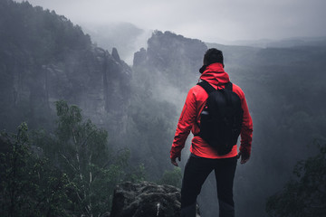 Wanderer auf dem Berg mit Ausblick im Nebel