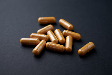 Turmeric capsules. Black background. Close up. 