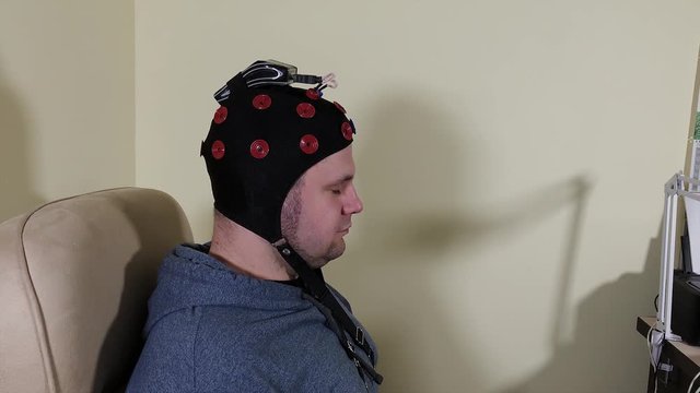 Doctor prepares headset for human brain research.