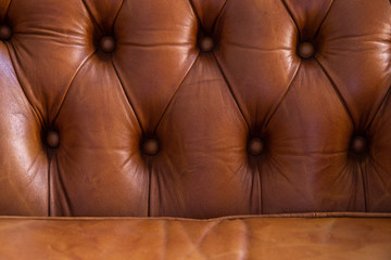 Genuine leather upholstery with rivets background for a luxury decoration in Brown tones