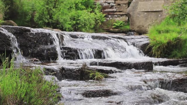 A slow motion close up view of South Dean Beck beneath the Bronte Waterfall near Haworth in West Yorkshire, England.