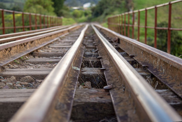 Fototapeta premium Perspective view of train tracks that goes over the Teatinos river, in the highlands of the Andean mountains of central Colombia.