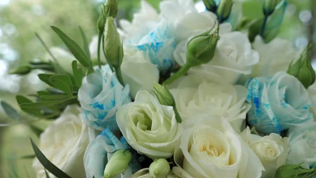 A bouquet of flowers tied with a cyan ribbon lies on a hemp. Shooting with a 3-axis motorized gimbal stabilizer.