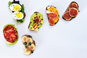 Six different toasts on the white background. Assorted toasts with eggs, fruits and berries,...