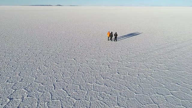 people walking salar de Uyuni from aerial view