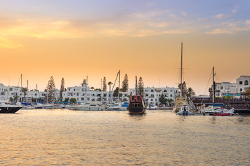 Amazing marina in Port El Kantaoui, Tunisia, colorful blue and golden sky, reflections in the sea and beautiful yachts and white villas and hotels