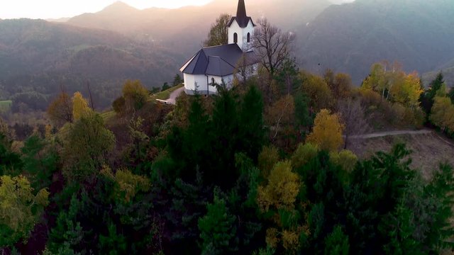 Aerial view of landscape of church of St. Primoz near Jamnik, Slovenia and Julian Alps at background