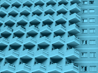 blue toned abstract image of a large residential highrise building with geometric rows of balconies
