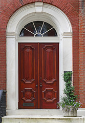 Elegant mahogany wood double door, entrance to an old townhouse or apartment building.