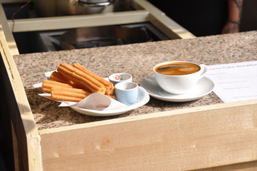 Churros con chocolate served in a restaurant.