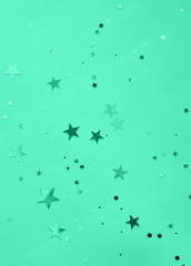 Texture of sparkling glitters in aquamarine background.