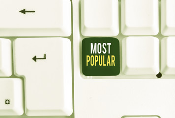 Conceptual hand writing showing Most Popular. Concept meaning Liked Followed Enjoyed by majority of the showing in a society White pc keyboard with note paper above the white background