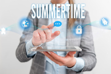 Handwriting text Summertime. Conceptual photo Longer daylight Tropical season Beach activities Vacation Female human wear formal work suit presenting presentation use smart device