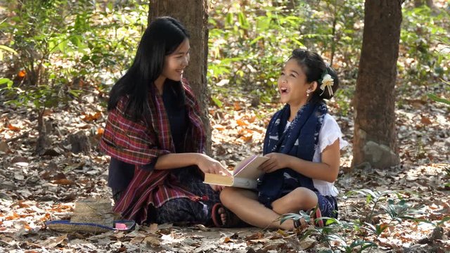 Asian woman and her little girl relaxing in Rubber plantation