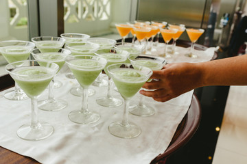 Many ice cream glasses ready to be served by a waiter during a wedding.