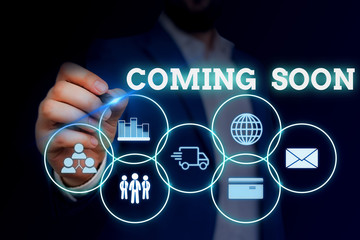 Handwriting text writing Coming Soon. Conceptual photo something is going to happen in really short time of period Male human wear formal work suit presenting presentation using smart device