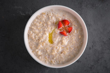 Healthy breakfast. Porridge of cereals, oatmeal, wheat, with strawberry and butter
