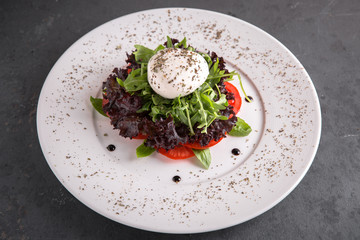 Healthy breakfast. Vitamin salad caprese from arugula, mozzarella, tomatoes and pesto sauce with oregano