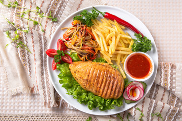 Grilled chicken fillet. A juicy piece of meat with vegetables, mushrooms, sauce and French fries. Restaurant menu. Isolated on white