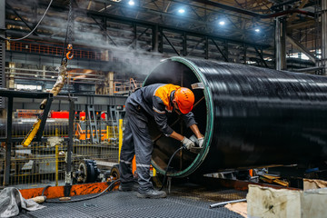 Worker installs clamping ring on coated pipe