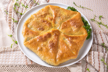 Pies with potatoes, cottage cheese, cabbage and apple. Plateau with sliced vertuta.