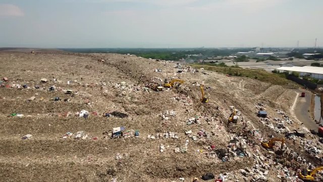 JAKARTA, Indonesia - September 13, 2019: Aerial view of high landfill with backhoe and scavenger. Shot in 4k resolution
