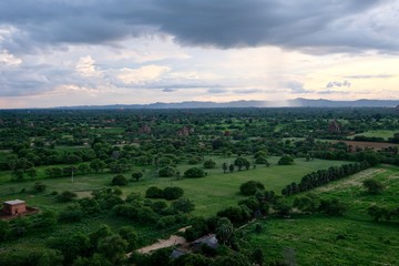 aerial view of wide green landscape under cloudy sunset sky. In Bagan Myanmar